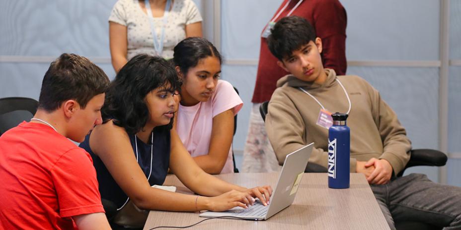Summer Planning Academy participants gather around a laptop.