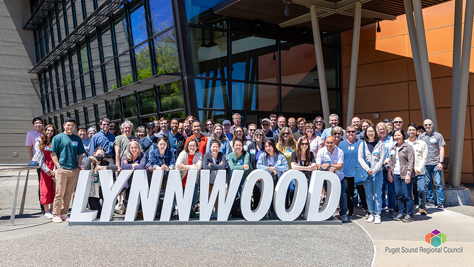 PSRC staff pose outside Lynnwood Convention Center with sign that reads, "Lynnwood."