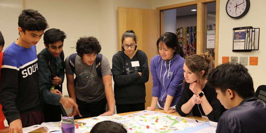 Group of people surrounding and looking at a map